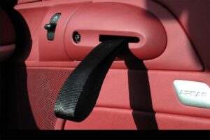 Porsche looked everywhere for ways to cut weight on the 2010 Boxster Spyder, even replacing the door handle with a cloth grab strap.