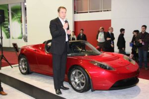 Tesla Motors founder Elon Musk, shown here .with the Tesla Roadster, at the Detroit Auto Show, January 2009