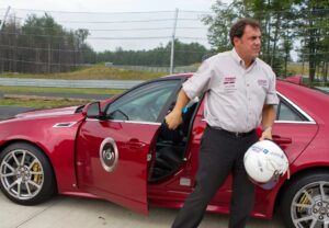 General Motors President North America Mark Reuss gets out of the Cadillac CTSv after taking the vehicle on hot laps around the track at the Monticello Motor Club.