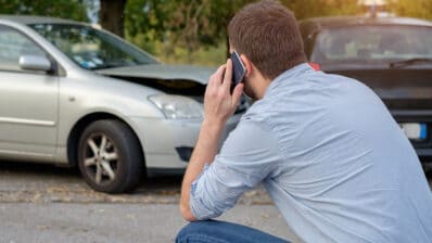 Man calling car mechanic insurance assistance after car accident