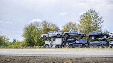 Big rig car hauler semi truck transporting cars on two level sem