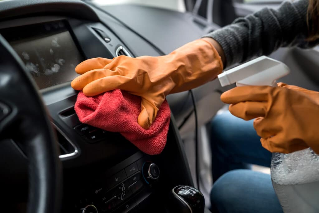 mão do trabalhador usar luvas de limpeza do interior do carro para prevenção covid-19